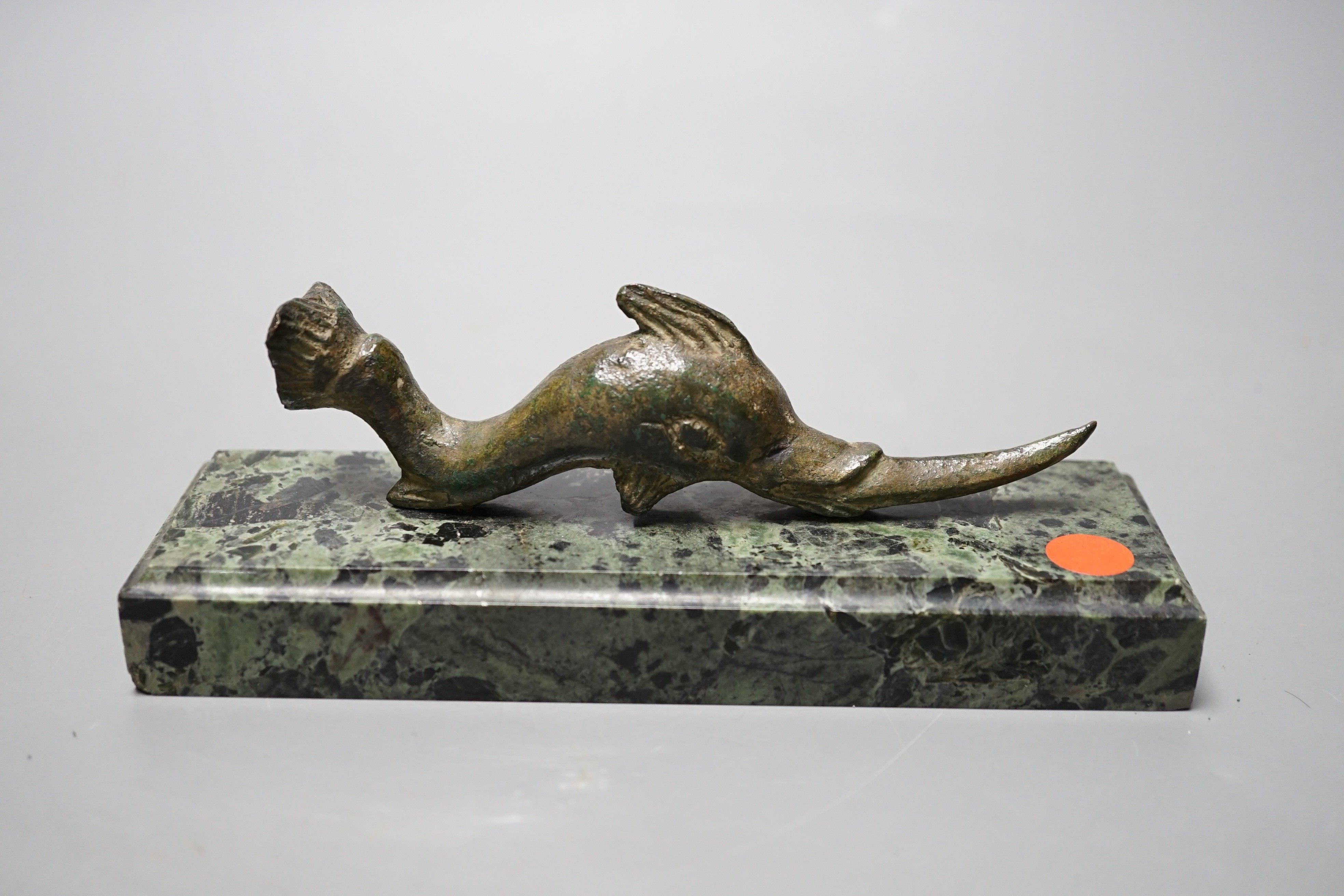 A Roman or later bronze dolphin, mounted as a paperweight on serpentine marble base, 16cm long